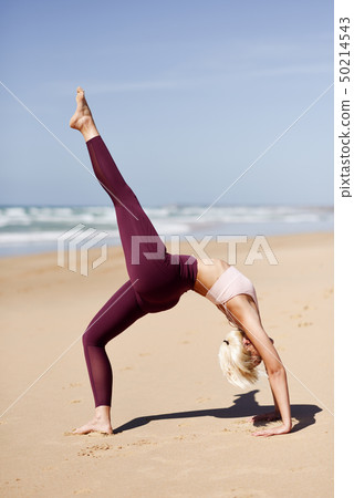 Caucasian blonde woman practicing yoga in the 50214543