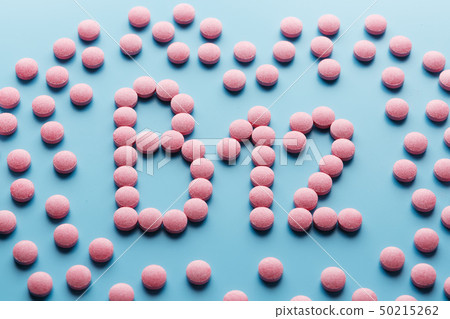 Pink pills in the shape of the letter B12 on a 50215262