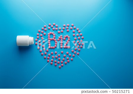 Pink tablets in the form of B12 in the heart on a 50215271