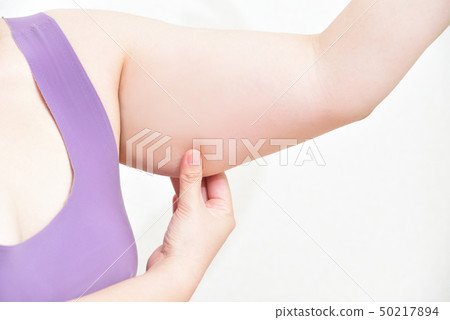 Woman pinching upper arm with finger 50217894