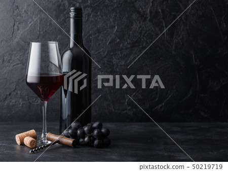 Elegant glass and bottle of red wine with corks 50219719