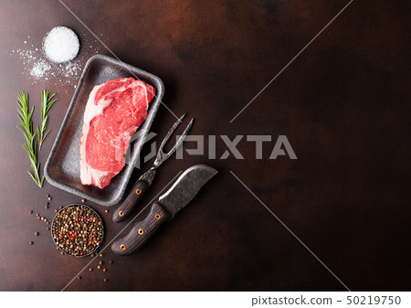 Raw sirloin beef steak in plastic tray with knife Raw sirloin beef steak in plastic tray with knife 50219750