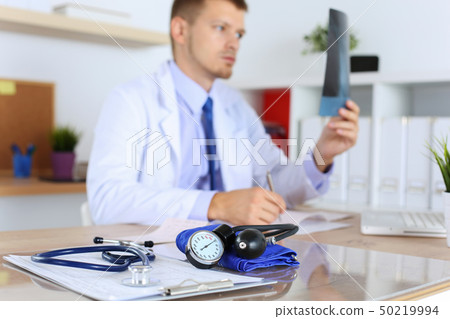 Medical manometer lying on cardiogram chart closeup Medical manometer lying on cardiogram chart closeup 50219994