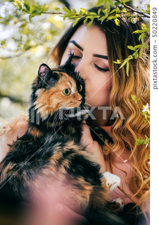 Girl and cat. Spring or summer warm weather concept. Bokeh background. Ginger kitten with two face Girl and cat. Spring or summer warm weather concept. Bokeh background. Ginger kitten with two face 50220849