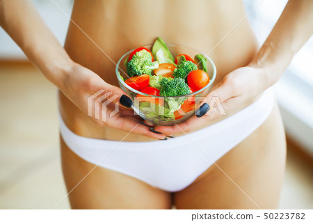 Health. Slim Girl Holding In Hands Fresh Salad. Young Girl in Wh 50223782
