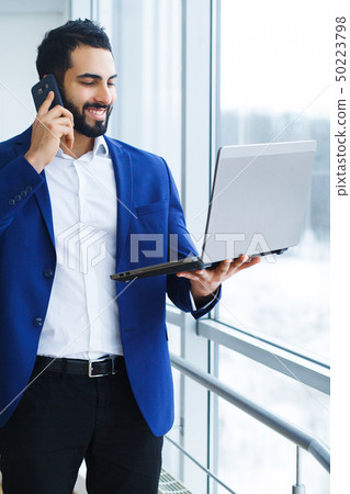 Happy business man talking on mobile phone 50223798