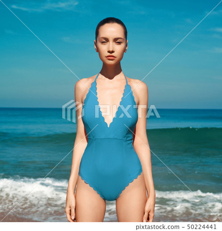 Beautiful sexy woman in blue swimwear on the beach 50224441