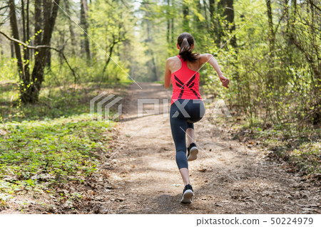 Fitness woman run in spring sunny forest 50224979