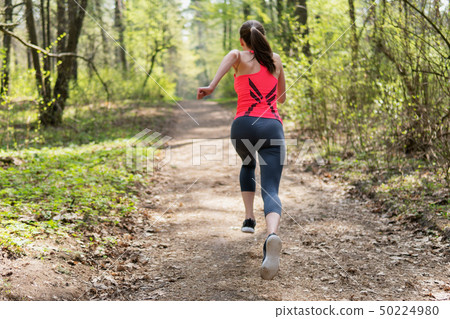 Active woman running in spring sunny forest 50224980