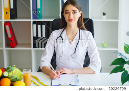 Health. Young Woman Dietitian Sitting At A Table With Fresh Fruits And Vegetables.High Resolution Health. Young Woman Dietitian Sitting At A Table With Fresh Fruits And Vegetables.High Resolution 50226709