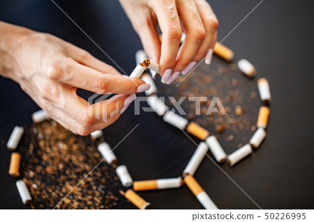 Stop smoking concept on background with broken cigarettes. Heap of cigarettes. No smoking 50226995