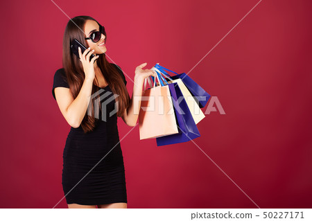Shopping. Women holding colored bags on red background in black friday holiday 50227171