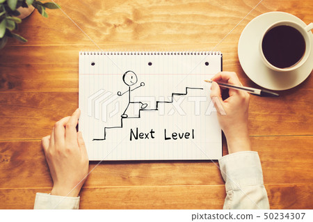 Next level concept with a person holding a pen Next level concept with a person holding a pen 50234307