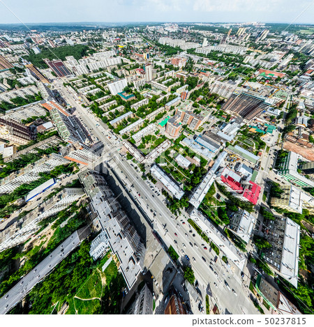 Aerial city view with crossroads and roads, houses, buildings, parks and parking lots. Sunny summer 50237815