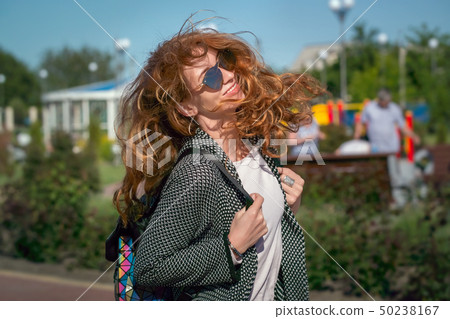 Wind waving red haired girl in sunglasses 50238167