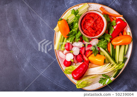 Plate with fresh, raw vegetables and sauce. 50239004