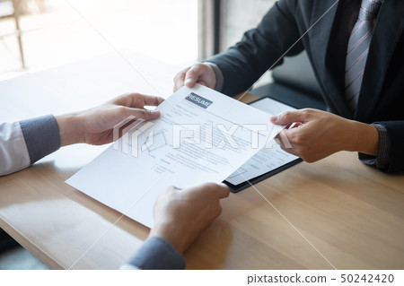 Employer or recruiter holding reading a resume Employer or recruiter holding reading a resume 50242420