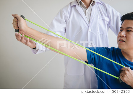 Doctor physiotherapist assisting a male patient Doctor physiotherapist assisting a male patient 50242563