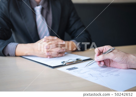 Employer or recruiter holding reading a resume Employer or recruiter holding reading a resume 50242652