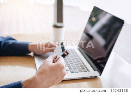 Businessman holding credit card and typing on 50243188
