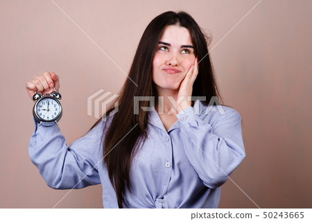 Bored and stressed woman with alarm clock Bored and stressed woman with alarm clock 50243665