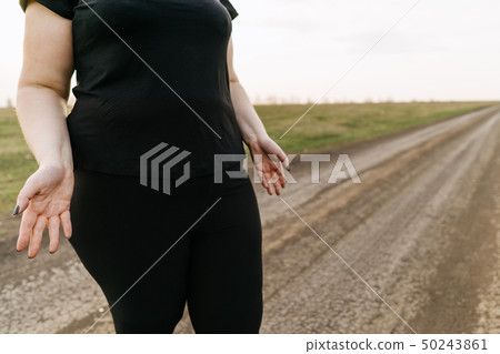 Overweight woman in despair spreading her hands 50243861