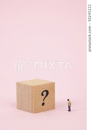 Miniature business man with question mark cubes Miniature business man with question mark cubes 50245221