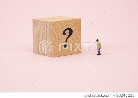 Miniature business man with question mark cubes 50245225