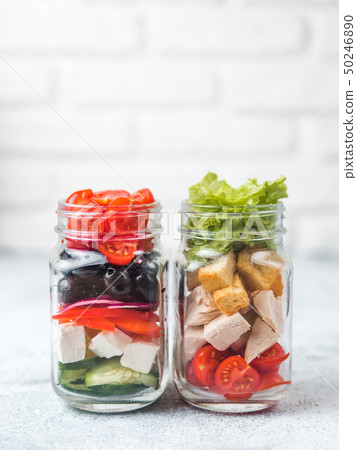 Caesar salad and Greek Salad in glass mason jar 50246890