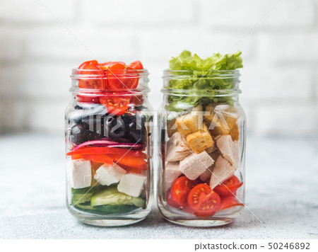 Caesar salad and Greek Salad in glass mason jar 50246892