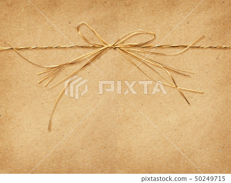 Raffia bow tied on craft paper Raffia bow tied on craft paper 50249715