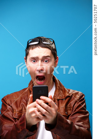 A man uses the phone and looks at the screen. A man uses the phone and looks at the screen. 50251707