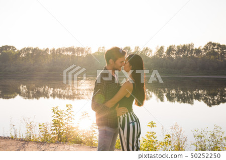 Love, romantic and nature concept - young couple hugging near the lake 50252250