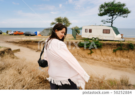 Beautiful, young girl posing on a wild seashore Beautiful, young girl posing on a wild seashore 50252884
