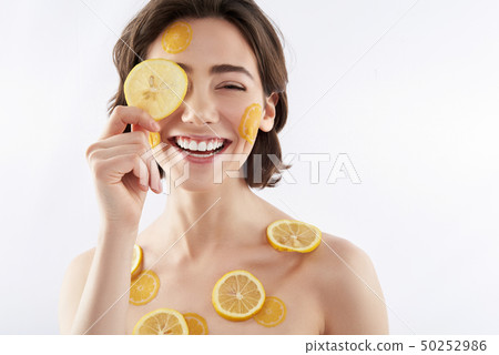 Happy smiling woman with many lemon pieces 50252986