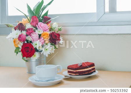 Red velvet and cup of coffee with bouquet rose 50253392