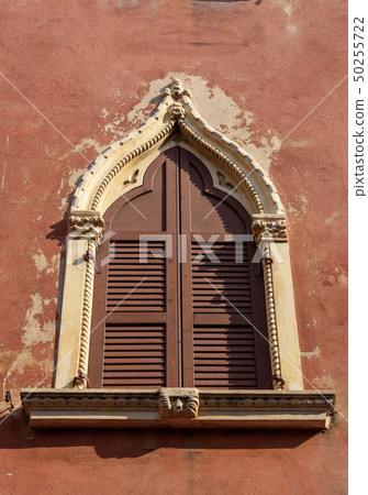 Arched window with wooden shutters of medieval Arched window with wooden shutters of medieval 50255722