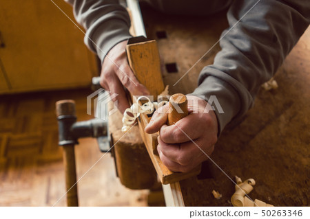 Top view of carpenter hand working with wood planer 50263346