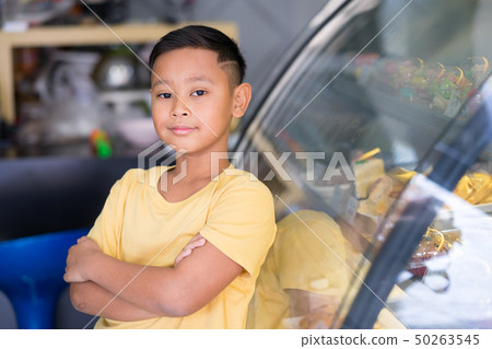 Asian kid boy waiting at bakery shop and choosing Asian kid boy waiting at bakery shop and choosing 50263545