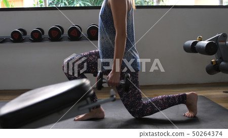 Young Athletic woman in gym working out with weights. Young Athletic woman in gym working out with weights. 50264374