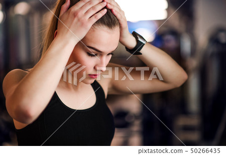 A portrait of young girl or woman standing in a gym. A portrait of young girl or woman standing in a gym. 50266435