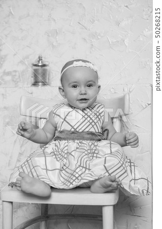 a little girl in a dress sits on a chair and a little girl in a dress sits on a chair and 50268215