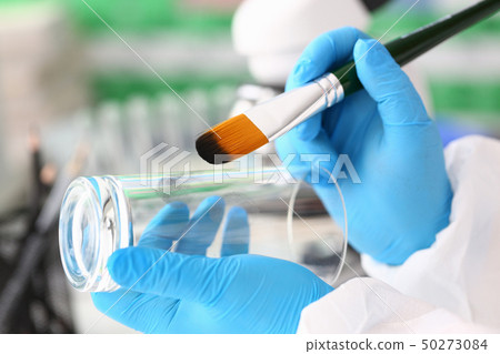 Male hand in blu protective gloves hold brush 50273084