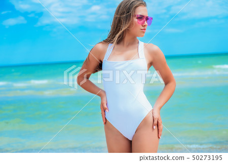A beautiful young girl in a white swimsuit  50273195