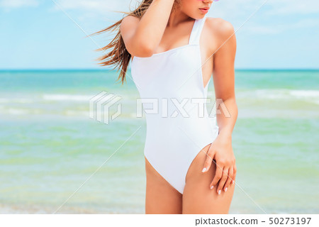 A beautiful young girl in a white swimsuit  50273197