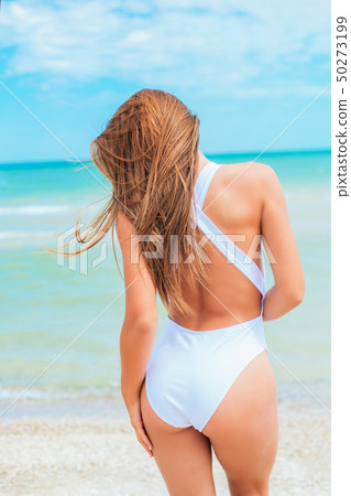 A beautiful young girl in a white swimsuit  50273199