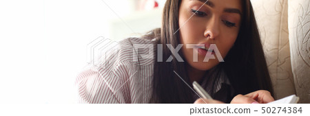 Smiling mellenial woman write story in Smiling mellenial woman write story in 50274384