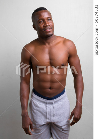 Young muscular African man shirtless against white background Young muscular African man shirtless against white background 50274533