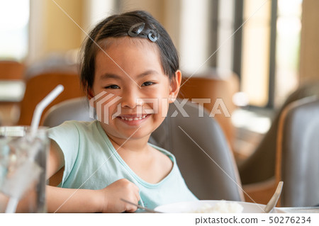 Little Asian girl at food table 50276234