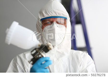 Workman hold in arm airbrush gun wearing protective suit 50276278